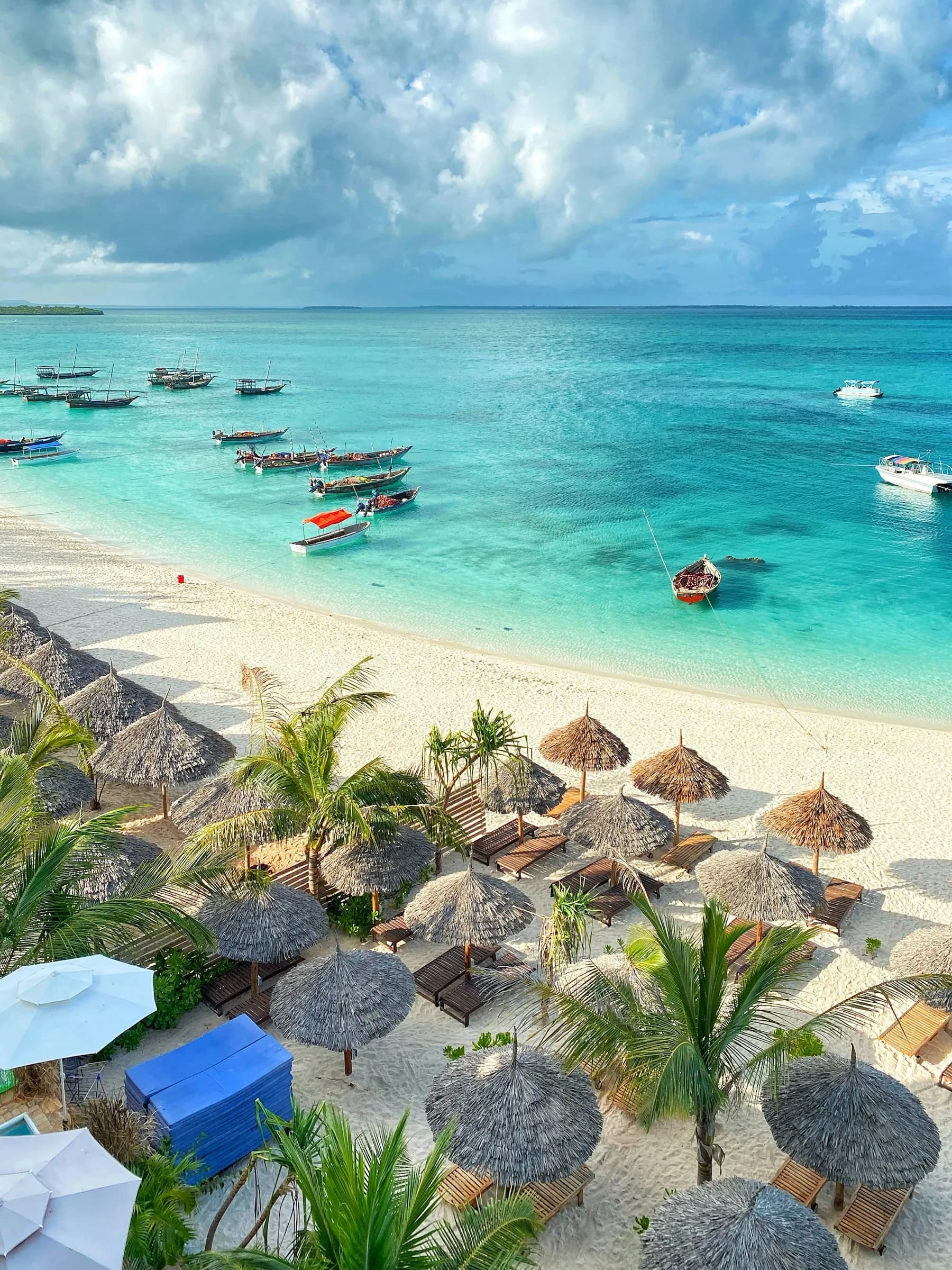 Wooden boats beside a white sand island beach
